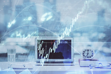 Forex graph hologram on table with computer background. Multi exposure. Concept of financial markets.