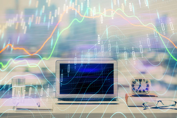 Stock market graph on background with desk and personal computer. Double exposure. Concept of financial analysis.