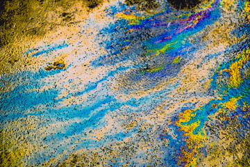Oil stain on Asphalt road after rain, color Gasoline fuel spots on Asphalt Road