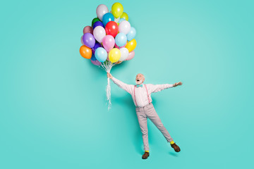 Full length photo amazed excited pensioner man hold many helium balloons flying wind sky he...