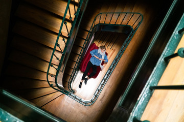 Fototapeta premium A woman is lying and resting on a couch in a cool traditional Lisbon hotel. The photo was taken from the top of spiral staircase.