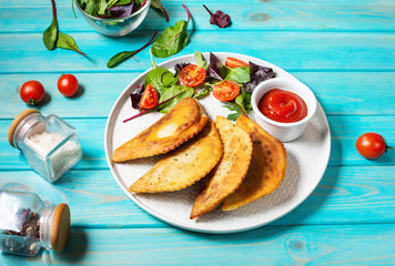 Latin American, mexican, chilean food. Traditional baked pastry empanadas with beef meat on blue wooden background