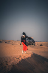 silhouette of woman in a desert at sunset