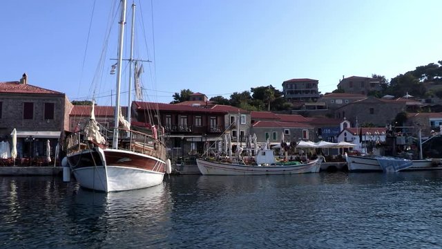 Traditional wooden boat and houses at the port of Molyvos, Lesvos, tracking shot