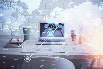 Computer on desktop with social network hologram. Multi exposure. Concept of international people connections.