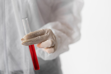 Medical doctor or laborant in hazmat protective suit holding tube with nCoV Coronavirus vaccine for 2019-nCoV virus. Novel Coronavirus originating in Wuhan, China.