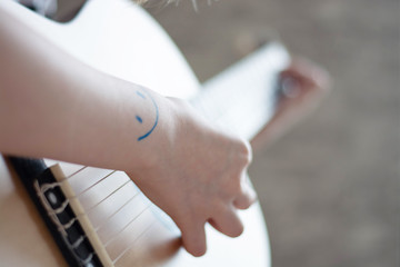 woman's hands playing acoustic guitar, close up