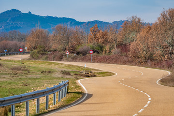 Curved road towards the mountain range, winter time