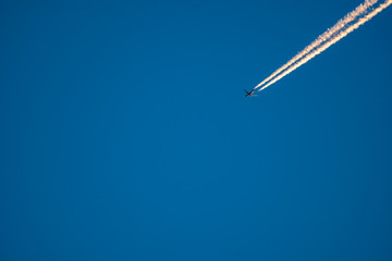 Jet plane trail crossing the sky from top right to bottom left