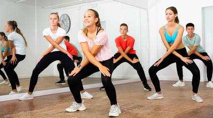Fototapeta na wymiar Teenage dancers practicing active vigorous dance in modern studio