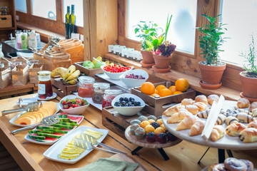 BREAKFAST BUFFET TABLE FILLED WITH ASSORTED FOODS