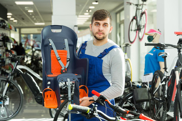 man seller standing with kids bicycle chair