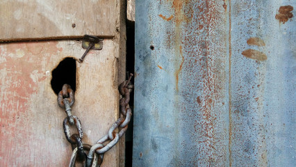 a locked wooden door with padlock and chain