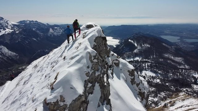 Group of hikers on snowy mountain ridge, Grigna, Lecco, Italy