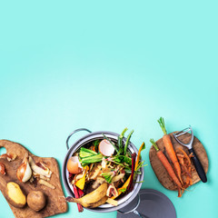 Top view of kitchen food waste collected in recycling compost pot. Peeled vegetables on chopping...