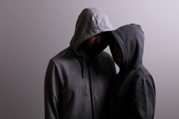 Man and woman hooded hugging, low key