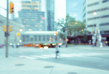 Blurred a man walking on pedestrian crossing the street in the city with traffics light colorful bokeh and buildings background.