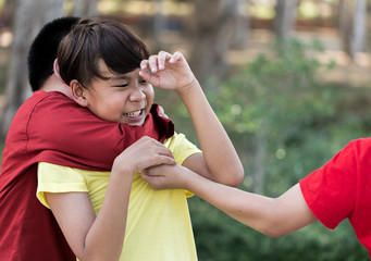 frightened Asian schoolboy being bullied playground in school. gang Children bullying their...