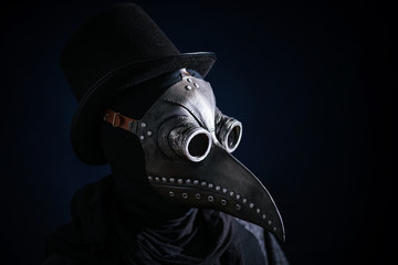 Masked man plague doctor, head profile, with bird mask and hat. Vintage style. Biohazard concept.