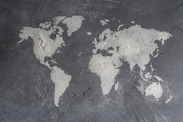 The contours of the map of the world from flour on a stone surface