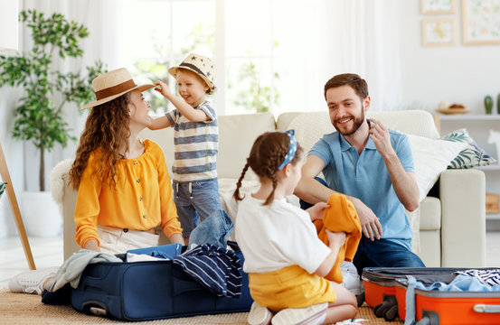 Playful family packing for holiday at home