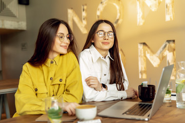 Female students searching information on laptop for studying