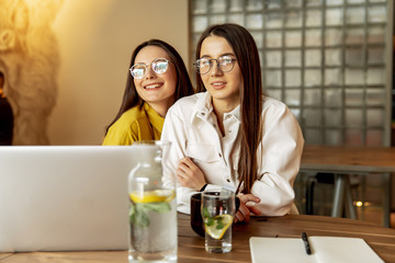 Female students searching information on laptop for studying