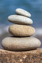 Fototapeta na wymiar Stones balance, pebbles stack over blue sea in Croatia. Blue sky on sunny adriatic coast in summer