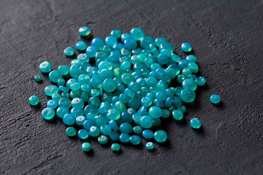 Blue opal. A bunch of natural stones of blue opal lies on a black modern background. Natural stones, minerals to create jewelry. Beautiful turquoise natural stones. Copy space for your text