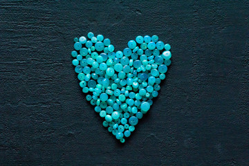 Heart Blue opal. A bunch of natural stones of blue opal lies on a black modern background. Natural...