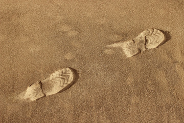 Traces of shoes in the sand. Footprints in the sandy ground.