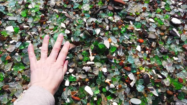 glass beach. many small fragments of glass carved by the sea lie on the beach. environmental pollution.