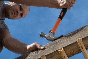 Soft focus construction worker repairing house.
