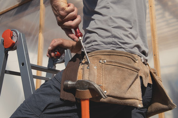 Close up tool belt with tools on construction worker at work. - obrazy, fototapety, plakaty
