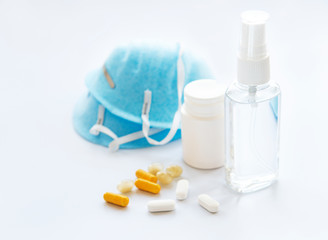 Antiseptic spray, pills and blue medical mask