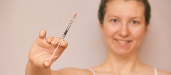 Girl hold insulin injection in hand. Blurred face. Anri virus vaccine. Woman nurse background....