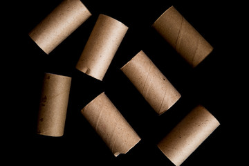 Conceptual photo of  empty toilet paper rolls set on dark background