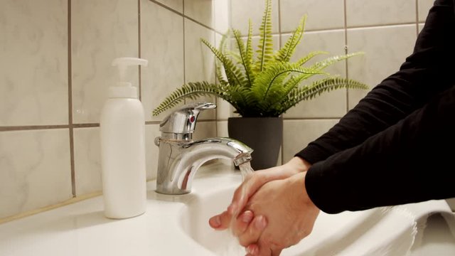 Staying healthy concept, male washes hands to protect from viruses and bacteria 