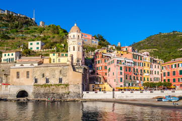 Vernazza, Cinque Terre - beautiful village with colorful buildings and church near sea. Cinque Terre National Park with cliffs and hiking trails is famous tourist destination in Liguria, Italy