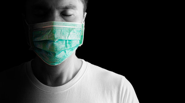 asian man at risk of infection in coronavirus covid 19 wearing mask on black background