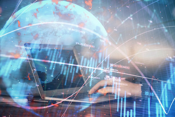 Double exposure of stock market graph with man working on laptop on background. Concept of financial analysis.