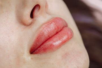 Lips after permanent makeup in beauty salon - obrazy, fototapety, plakaty