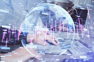 Multi exposure of chart with man typing on computer in office on background. Concept of hard work.