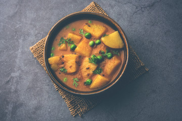 Aloo Curry Sabzi made using boiled potato with green peas. Served in a bowl or karahi, selective focus