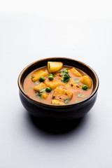 Aloo Curry Sabzi made using boiled potato with green peas. Served in a bowl or karahi, selective focus