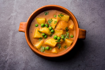 Aloo Curry Sabzi made using boiled potato with green peas. Served in a bowl or karahi, selective focus