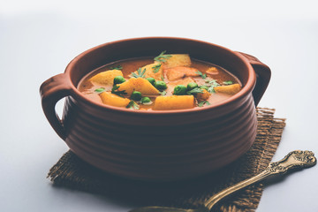 Aloo Curry Sabzi made using boiled potato with green peas. Served in a bowl or karahi, selective focus