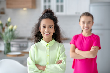Two girls standing in the kitchen and smiling