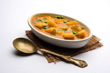Aloo Curry Sabzi made using boiled potato with green peas. Served in a bowl or karahi, selective focus