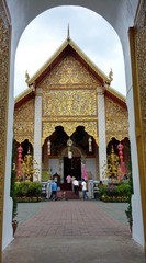 Fototapeta na wymiar Church of Wat Phra That Hariphunchai Lamphun, beautifully decorated with art in northern Thailand. Taken through the temple gate